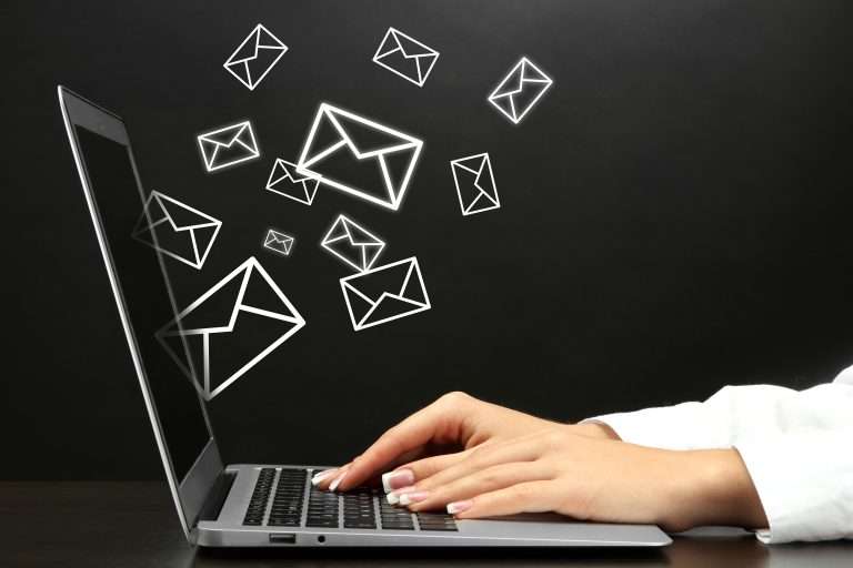 Someone sending out emails on a laptop